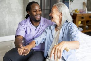 healthcare assistant supporting an older female patient to stand up