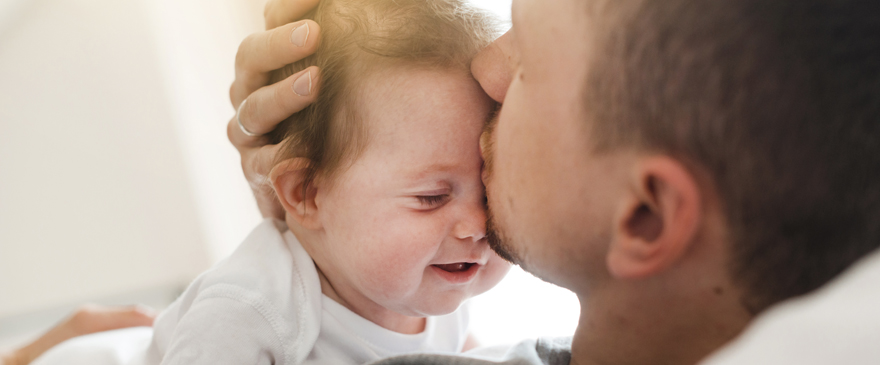 Father kissing baby.