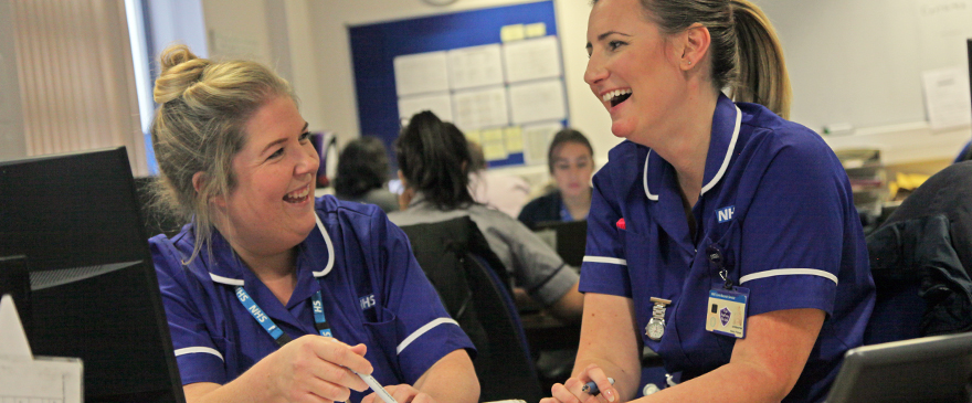 Two female nurses laughing.
