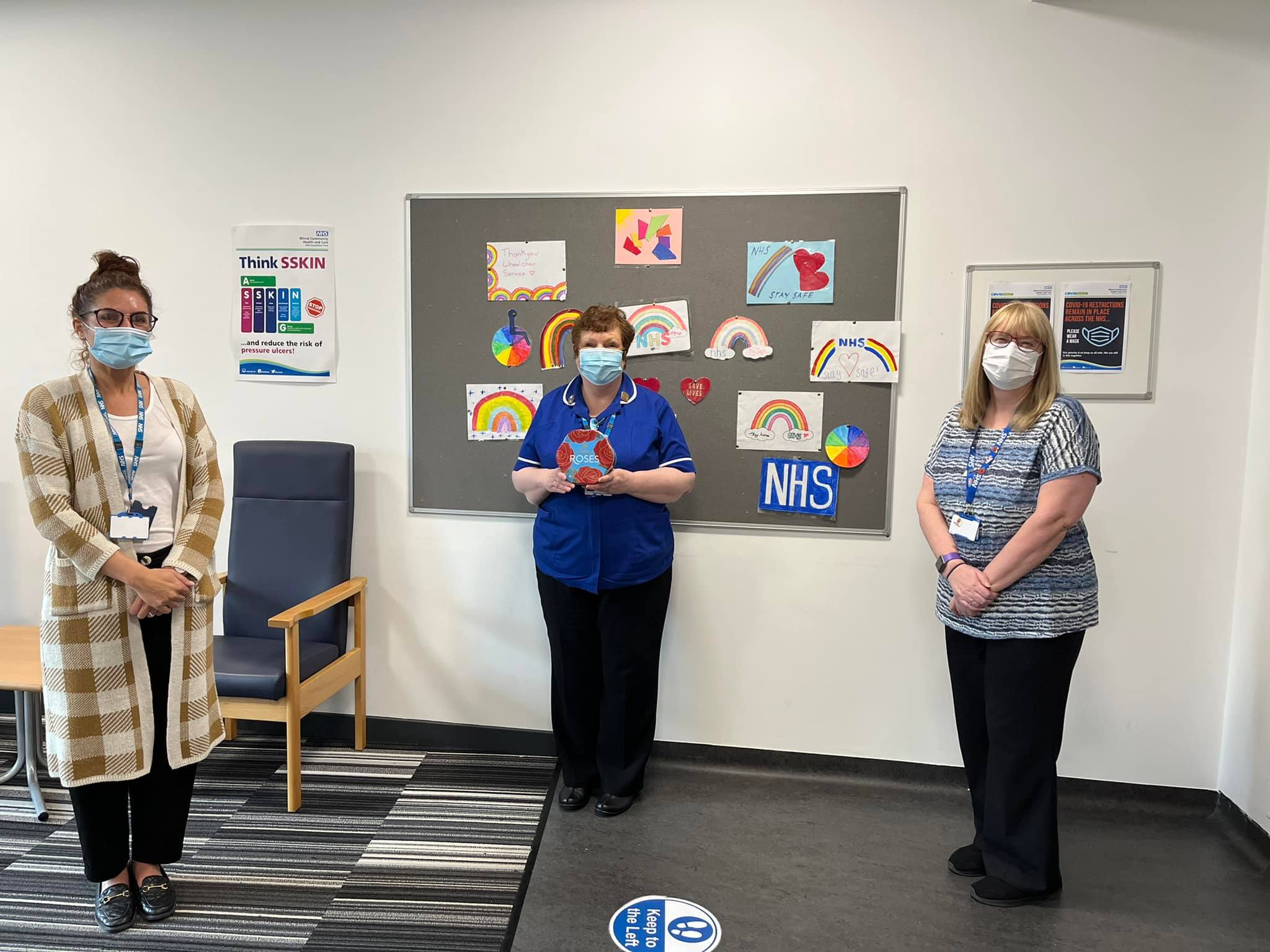 Staff in face masks smiling with gifts of chocolate