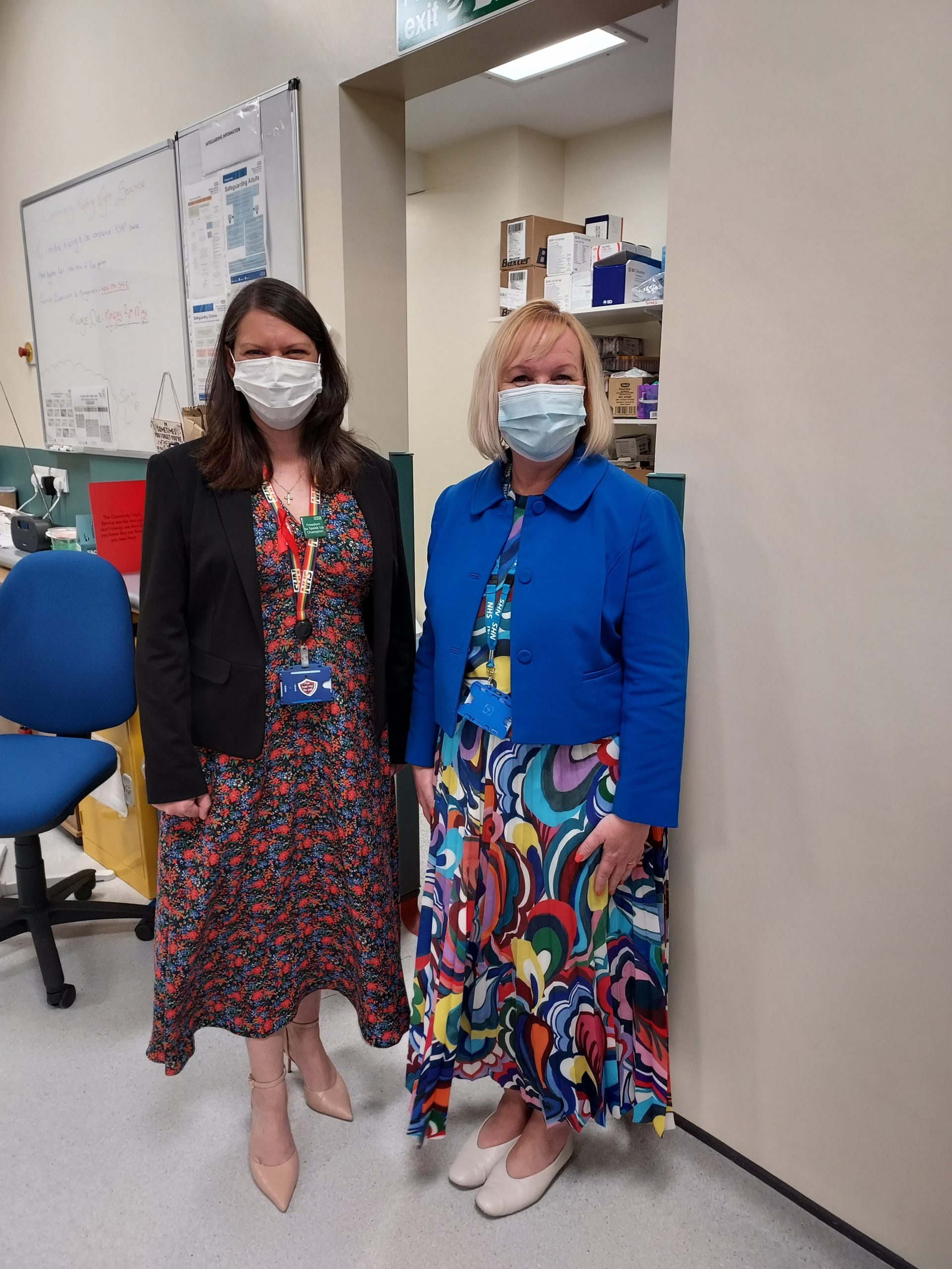 Members of staff wearing face coverings and NHS lanyards
