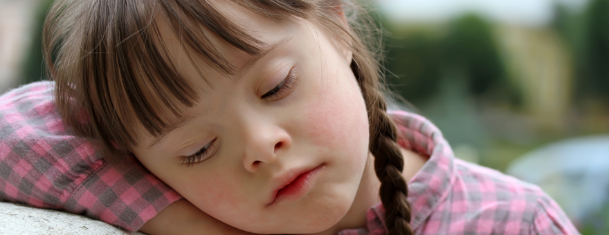 Young girl resting her head on her arm.