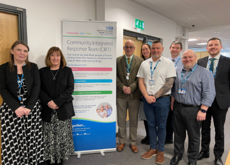 Group of people stood in office around roller banner (Community Integrated Response Team) 
Jo Chwalko, Chief Operating Officer, Dr Amanda Doyle OBE, National Director for Primary Care and Community Services, Simon Banks, Place Director, Jennifer Fell and Chris Burquest, CIRT
Service Leads, Mark Richards, Service Lead, David Hammond, Deputy Chief Strategy Officer, Bradley Palin, Deputy Chief Operating Officer
