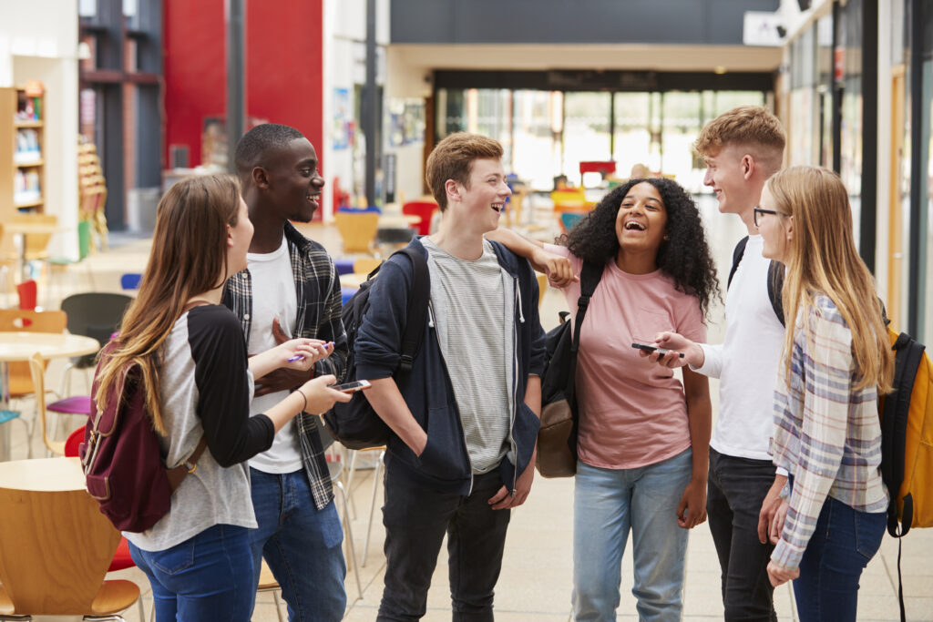 Group of six young people smiling and laughing.