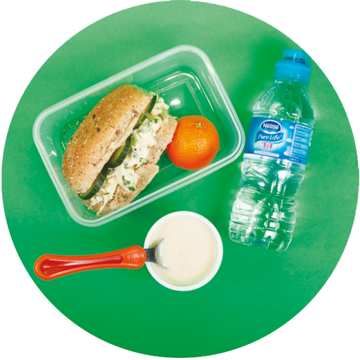 Image of a child's packed lunch which includes an egg, cress and cucumber seeded roll, rice pudding, satsuma and a bottle of water.