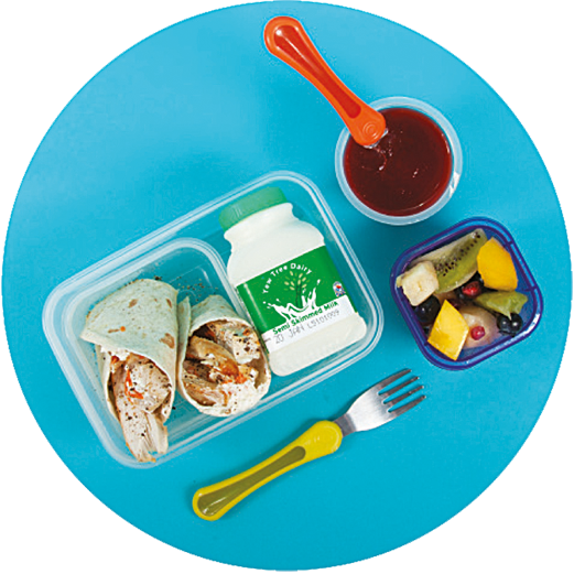 Image of a child's packed lunch which includes a chicken, cream cheese and grated carrot wrap, fruit kebab, sugar-free jelly and a carton of semi-skimmed milk.
