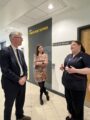 Man and woman from NHS providers stood with WCHC NHS nurse in uniform outside the Wirral Heart Support department