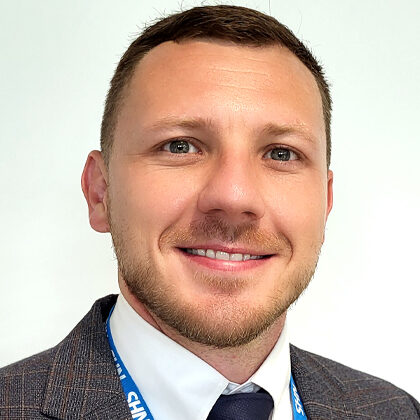 Man in suit and tie with NHS lanyard