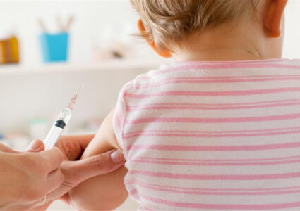 Photograph of a baby about to receive a vaccination.