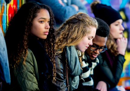 Group of young people sat next to each other.