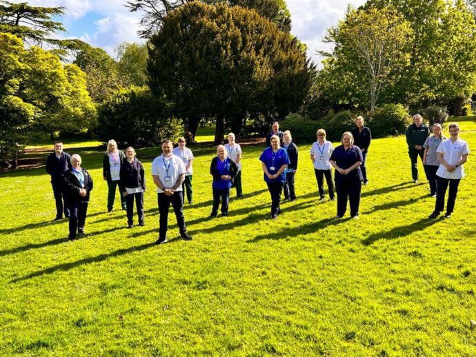 Rapid Response Team stood together outside, blue sky, trees and grass