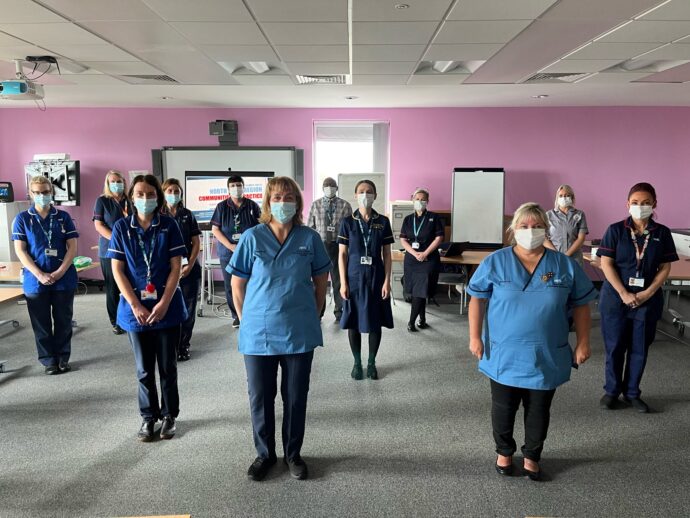 Staff in face masks smiling in a group