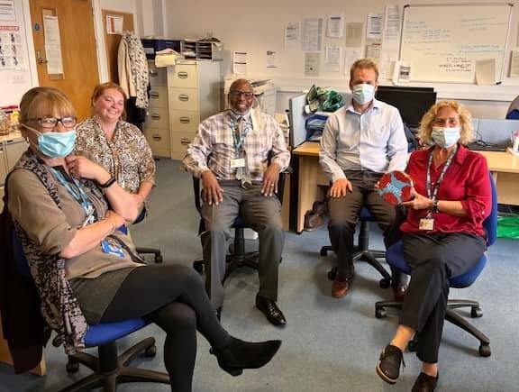 Staff in face masks smiling with gifts of chocolate