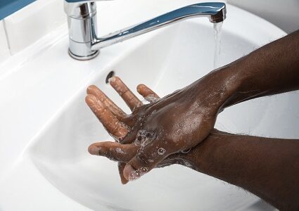 Hand washing with soap and water at a sink