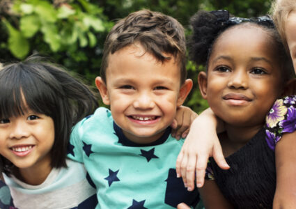 Group of young children hugging and smiling