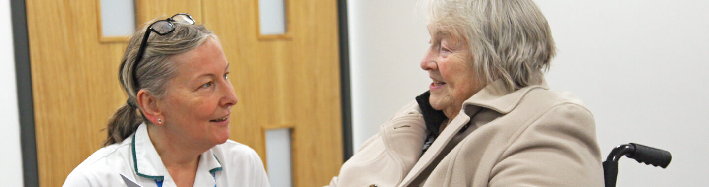 Wheelchair Service User talking with Occupational Therapist and smiling