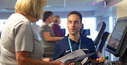 Exercise physiologist helping patient on fitness machine